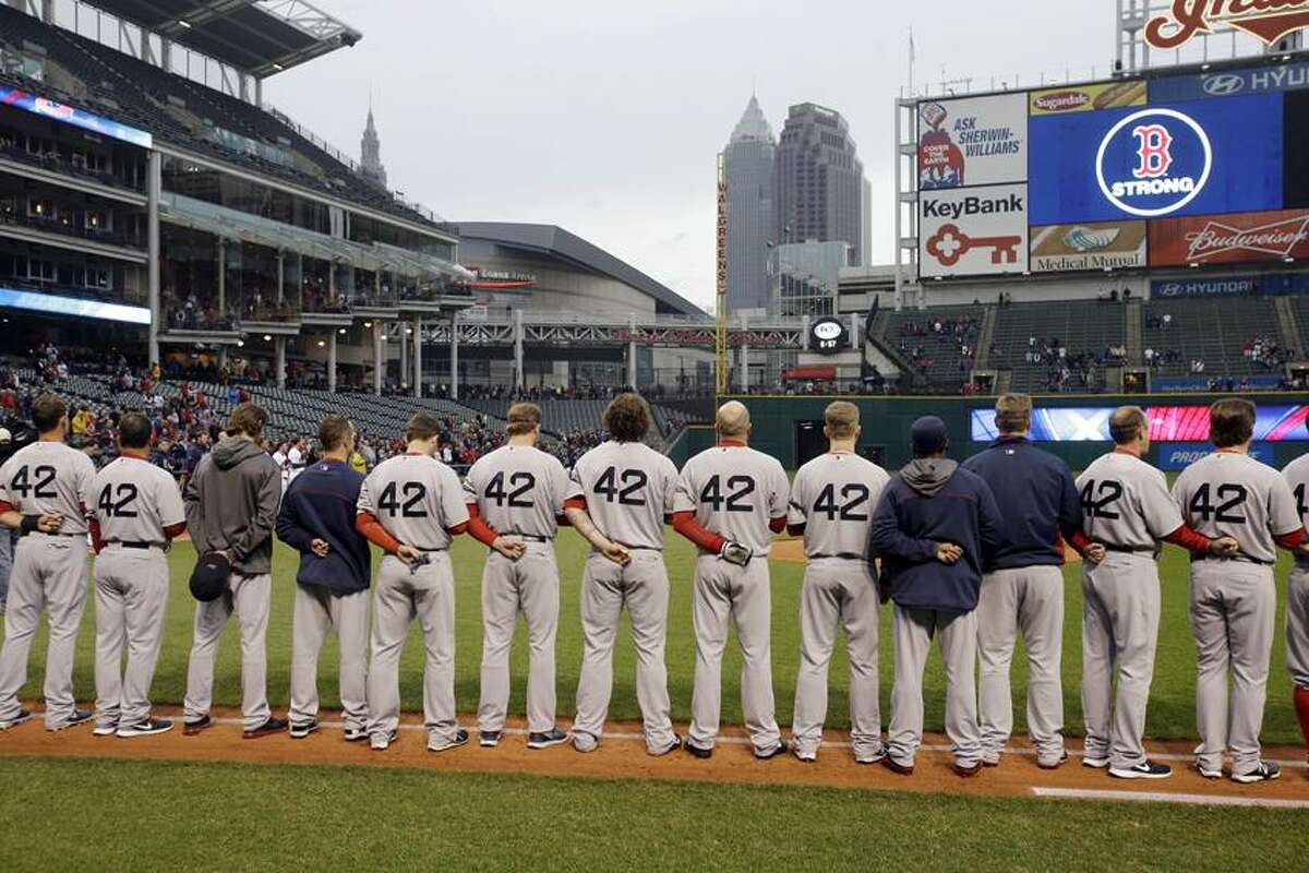 The Boston Red Sox players and coaches observe a moment of silence for the victims of the Boston bombings before a baseball game against the Cleveland Indians Tuesday, April 16, 2013, in Cleveland. (AP Photo/Mark Duncan)