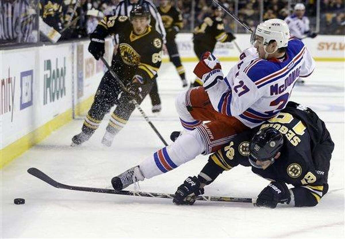 New York Rangers defenseman Ryan McDonagh (27) falls over Boston Bruins center Tyler Seguin (19) as they chase the puck during the second period of an NHL hockey game in Boston, Tuesday, Feb. 12, 2013. Boston Bruins left wing Brad Marchand (63) trails the play. (AP Photo/Elise Amendola)