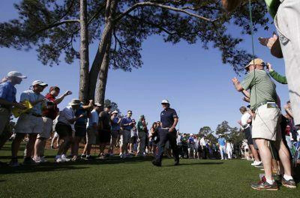 Phil Mickelson of the U.S. is applauded as he walks to the eighth tee during a practice round in preparation for the 2013 Masters golf tournament at the Augusta National Golf Club in Augusta, Georgia, April 9, 2013. REUTERS/Mike Segar (UNITED STATES - Tags: SPORT GOLF)