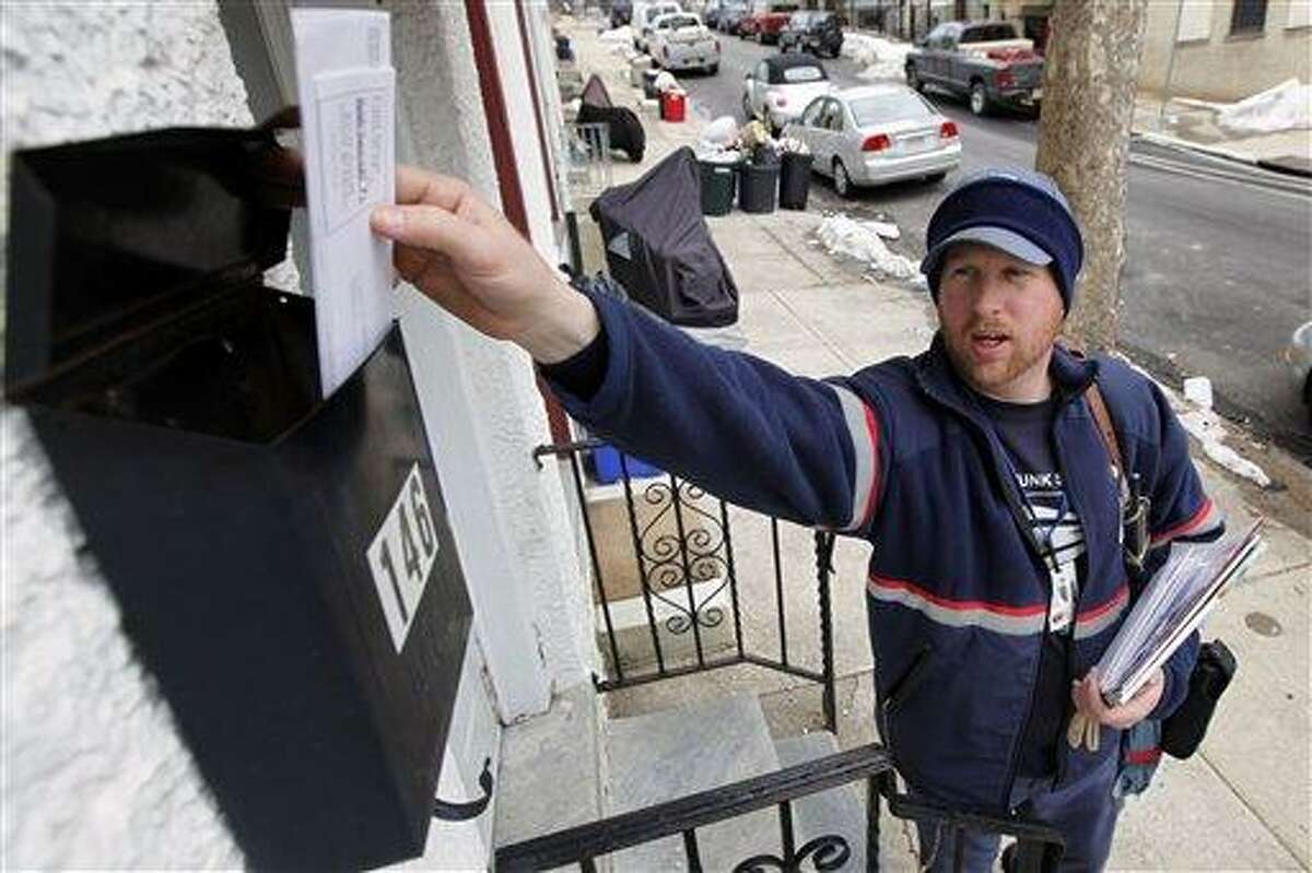 FILE - In this Tuesday, March 2, 2010 file photo, letter carrier Kevin Pownall delivers mail in Philadelphia. The financially struggling U.S. Postal Service announced on Wednesday, Feb. 6, 2013 it will stop delivering mail on Saturdays but continue to deliver packages six days a week under a plan aimed at saving about $2 billion a year. (AP Photo/Matt Rourke, File)