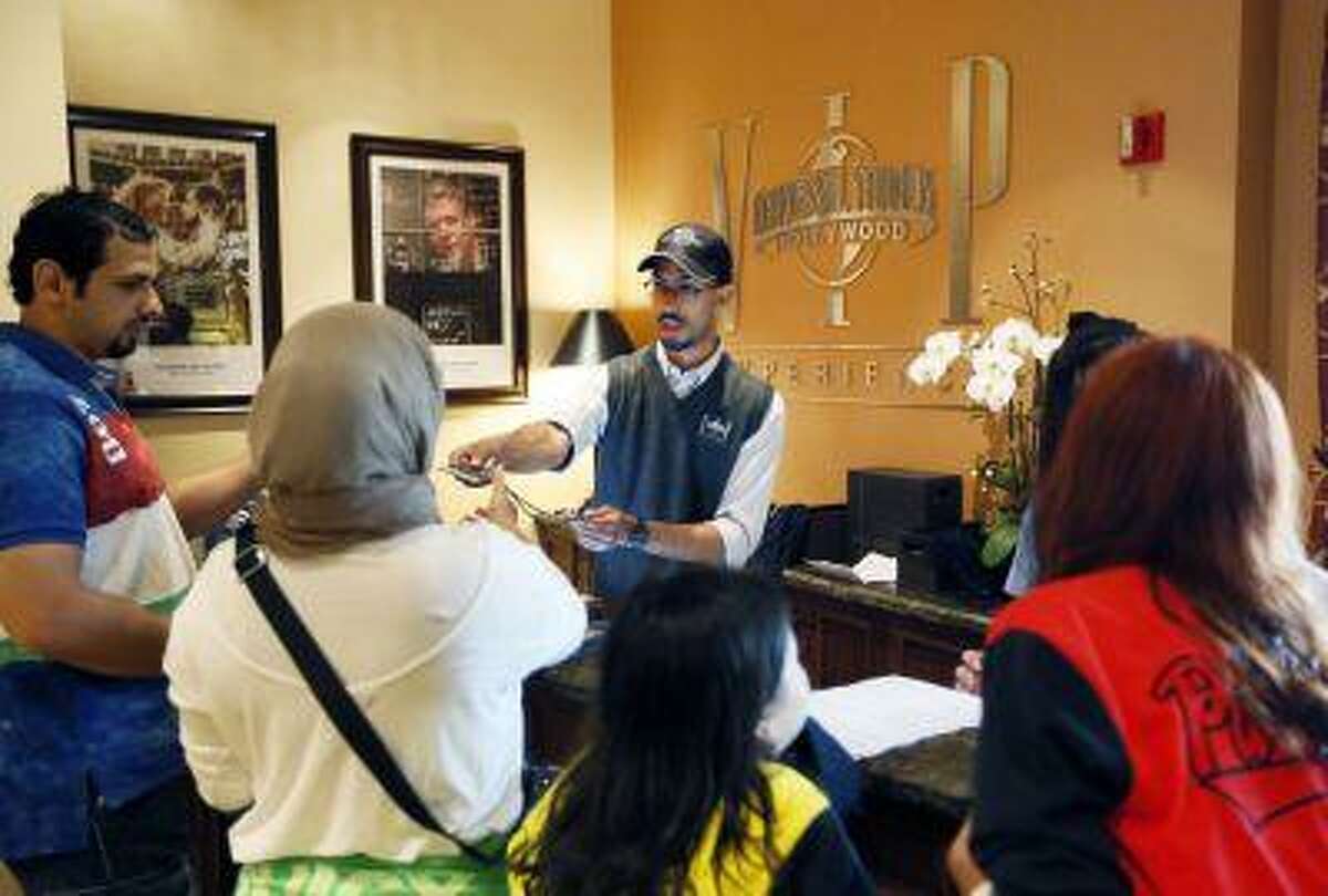 This photo taken Wednesday, June 5, 2013, show tourists at the VIP Experience counter at Universal Studios in Los Angeles. Many theme parks now have VIP tours with perks usually reserved for celebrities _ private tour guides, no waits for the biggest attractions, reserved seating at shows and parades along with behind-the-scenes peaks at places normally off limits. (AP Photo/Damian Dovarganes)