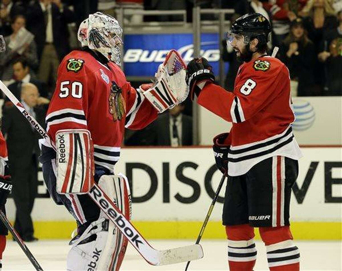 Chicago Blackhawks goalie Corey Crawford (50) celebrates with defenseman Nick Leddy (8) during the third overtime period of Game 1 in their NHL Stanley Cup Final hockey series, Thursday, June 13, 2013, in Chicago. (AP Photo/Nam Y. Huh)