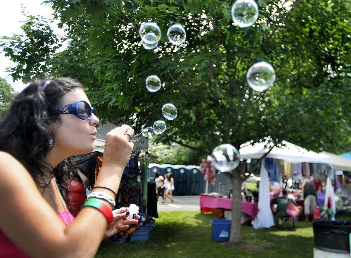 Melanie Stengel/Register file photo: Andrianna Trast takes some time off from the lia sophia jewelry booth to blow some bubbles at a previous edition of the Branford Festival.