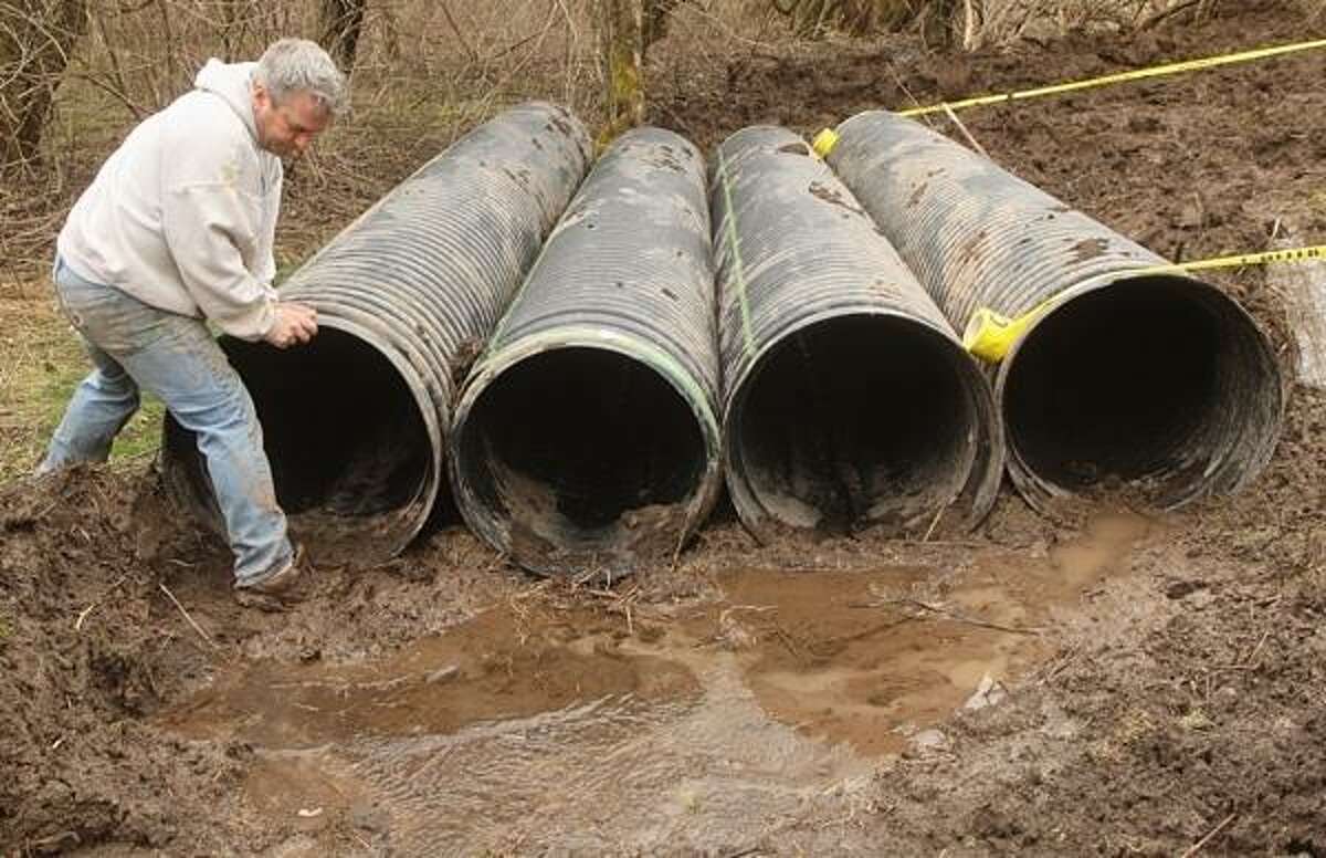 PHOTO BY JOHN HAEGER @ ONEIDAPHOTO ON TWITTER/ONEIDA DAILY DISPATCH David Poyer sets pipes which runner will have to crawl through during the Daniel Barden Highland Mudfest on Wednesday, April 10, 2013.