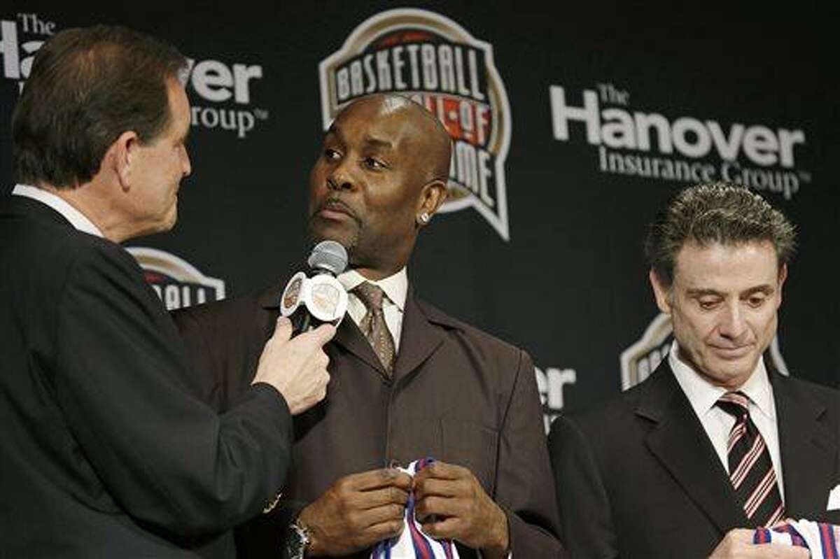 Former NBA player Gary Payton, center, talks with CBS announcer Jim Nantz, left, during the Naismith Memorial Basketball Hall of Fame class announcement, Monday, April 8, 2013, in Atlanta, Georgia. Louisville coach Rick Pitino, right, looks on. (AP Photo/Charlie Neibergall)