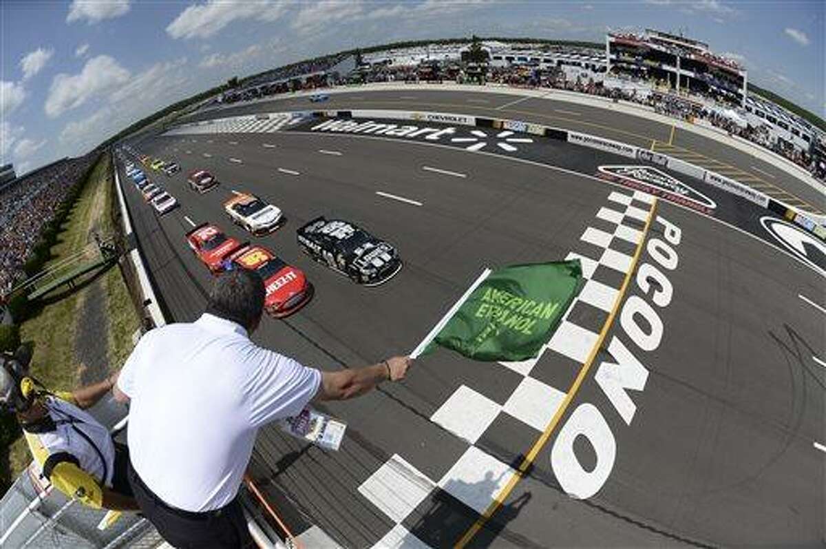 In this handout photo provided by NASCAR, Jimmie Johnson (48) and Carl Edwards (99) lead the field to the green flag to start the NASCAR Pocono 400 auto race, June 9, 2013 in Long Pond, Pa. (AP Photo/NASCAR, Patrick Smith)