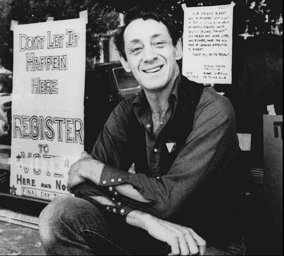 FILE - In a Nov. 9, 1977 file photo, Harvey Milk poses in front of his camera shop in San Francisco. A charter amendment sponsored by city Supervisor David Campos on Tuesday, Jan. 15, 2013 planned to introduce legislation asking voters to rename the city's airport after slain gay rights leader Harvey Milk. The amendment would put the question of creating Harvey Milk-San Francisco International Airport on San Francisco's November ballot. Milk became one of the first openly gay men elected to public office in the United States when he won a seat on the board of supervisors in 1977. He was assassinated at City Hall, along with Mayor George Moscone, more than a year later. (AP Photo, File)