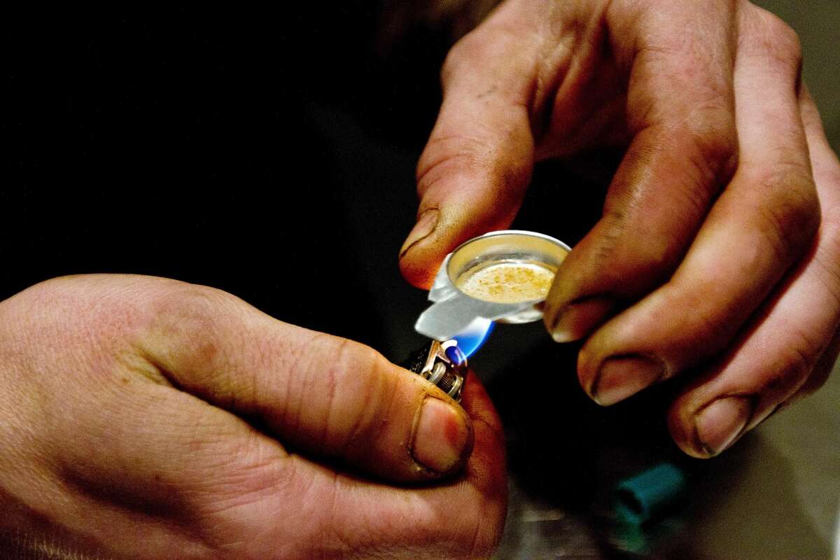 A client of the Insite supervised injection Center in Vancouver, Canada, prepares a dose of drug to inject on May 3, 2011.