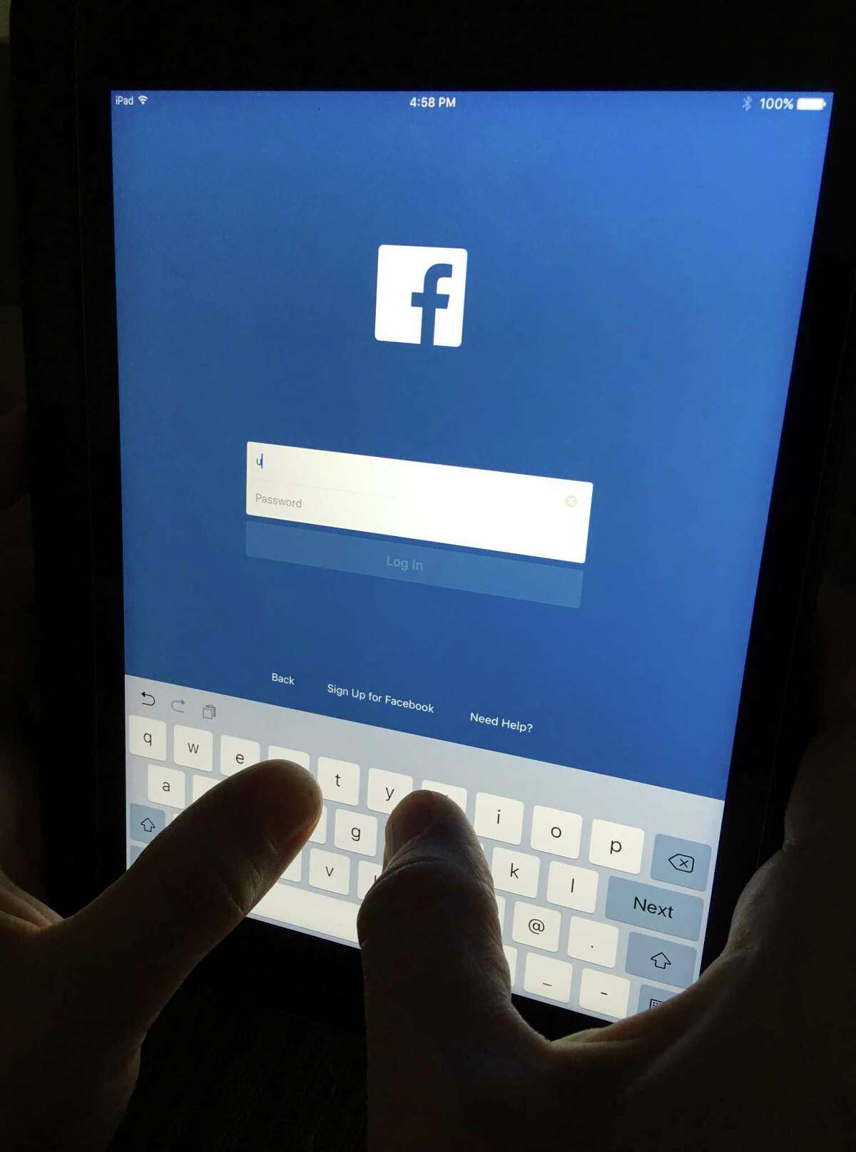 In this Monday, June 19, 2017, photo, a user signs into Facebook on an iPad, in North Andover, Mass. Facebook has squeezed just about as many ads into its main platform as it can. Any more and users might start to complain. Now, ads are moving on to Messenger, and WhatsApp may not be too far behind. (AP Photo/Elise Amendola)
