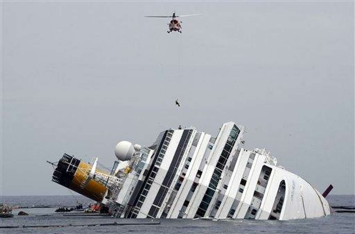An Italian firefighter is lowered from an helicopter onto the grounded cruise ship Costa Concordia off the Tuscan island of Giglio, Italy, Tuesday. Residents of Giglio are growing increasingly worried about threats to the environment and the future of the Italian island following the suspension of the recovery operation of the capsized cruise ship Costa Concordia. Associated Press