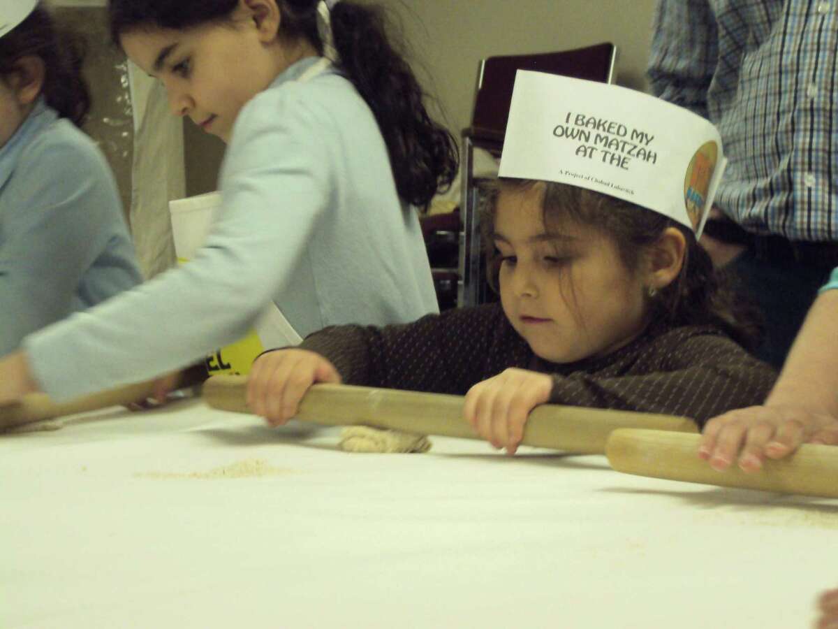 RICKY CAMPBELL/Register Citizen Children learn to roll matzah dough during Chabad Lubavitch's recent workshop in Litchfield.