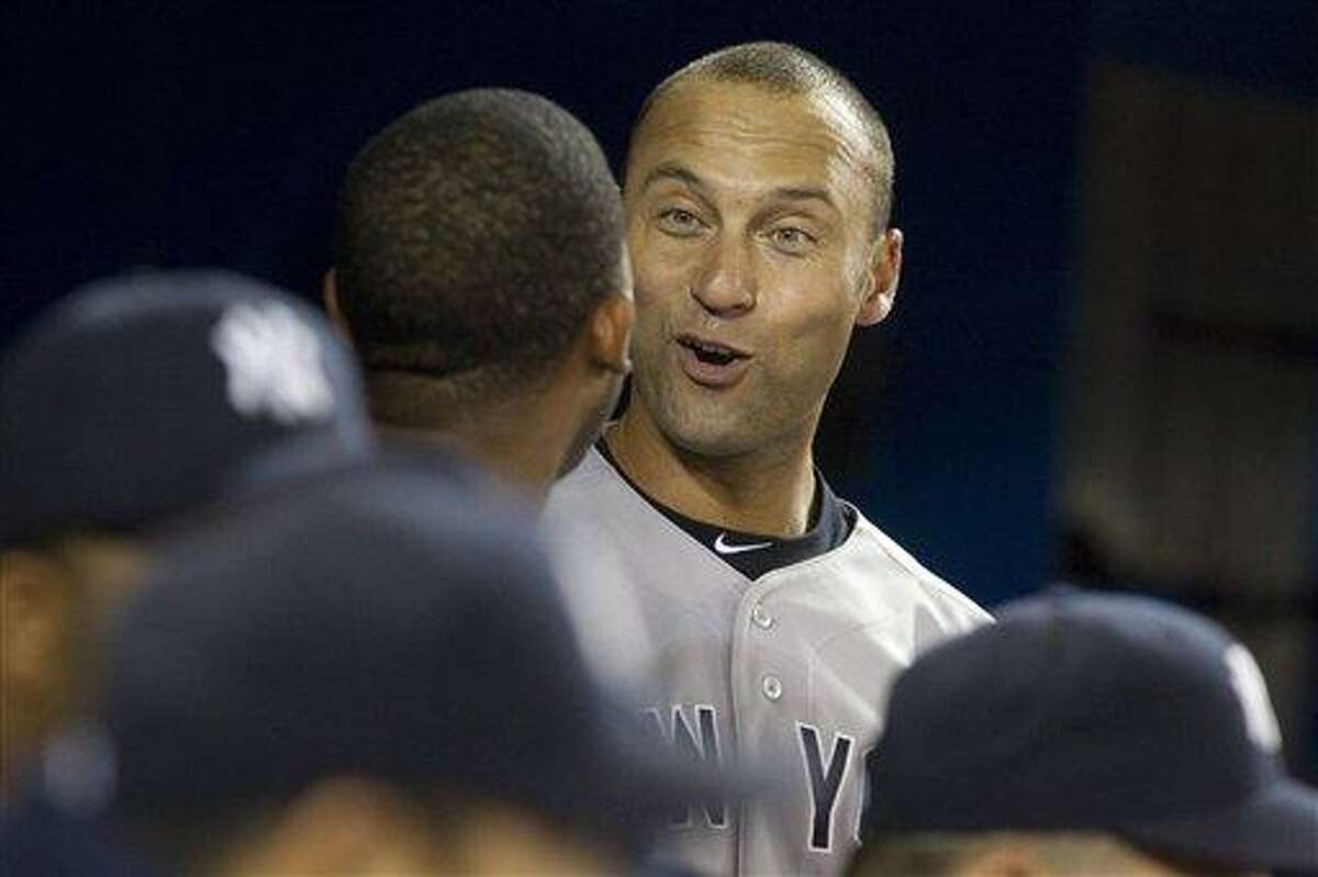 New York Yankees Derek Jeter ,right, chats with Eduardo Nunez after Jeter scored off a double from Robinson Cano against Toronto Blue Jays during seventh inning of a baseball game in Toronto on Sunday, Sept. 30 , 2012. (AP Photo/The Canadian Press, Chris Young)