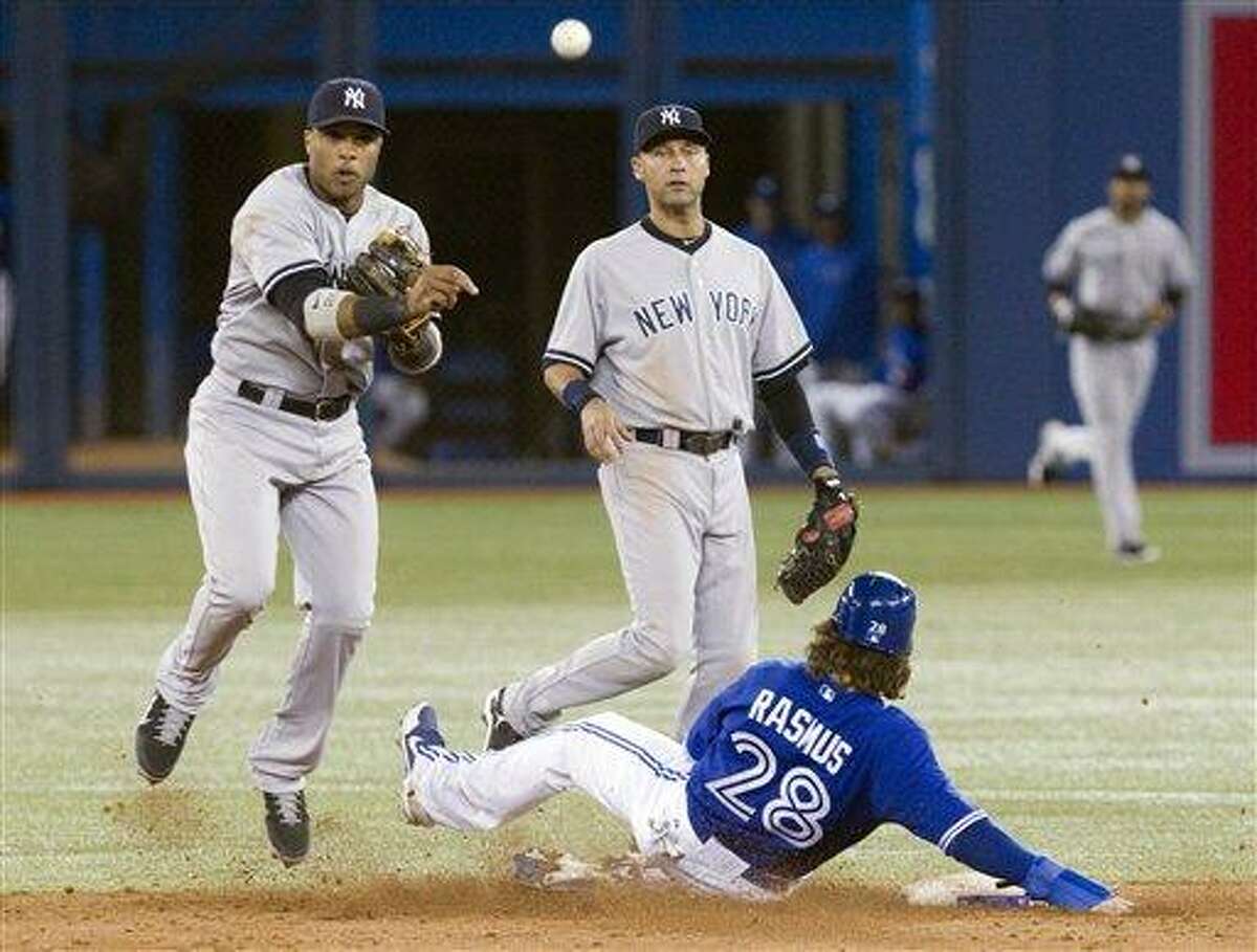 New York Yankees Robinson Cano, left, throws to first as Toronto Blue Jays Colby Rasmus is forced out at second on a double play as Derek Jeter, center, looks on during ninth inning of a baseball game in Toronto on Sunday, Sept. 30 , 2012. (AP Photo/The Canadian Press, Chris Young)