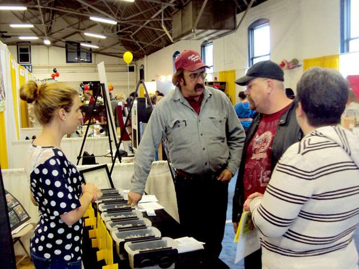 RICKY CAMPBELL/ Register Citizen Members of Mountaintop Trucking discuss business with visitors during Saturday's Home and Business Expo, an event by Northwest Connecticut's Chamber of Commerce. The expo featured more than 75 exhibitors Saturday, with the same number expected Sunday at the Torrington Armory.
