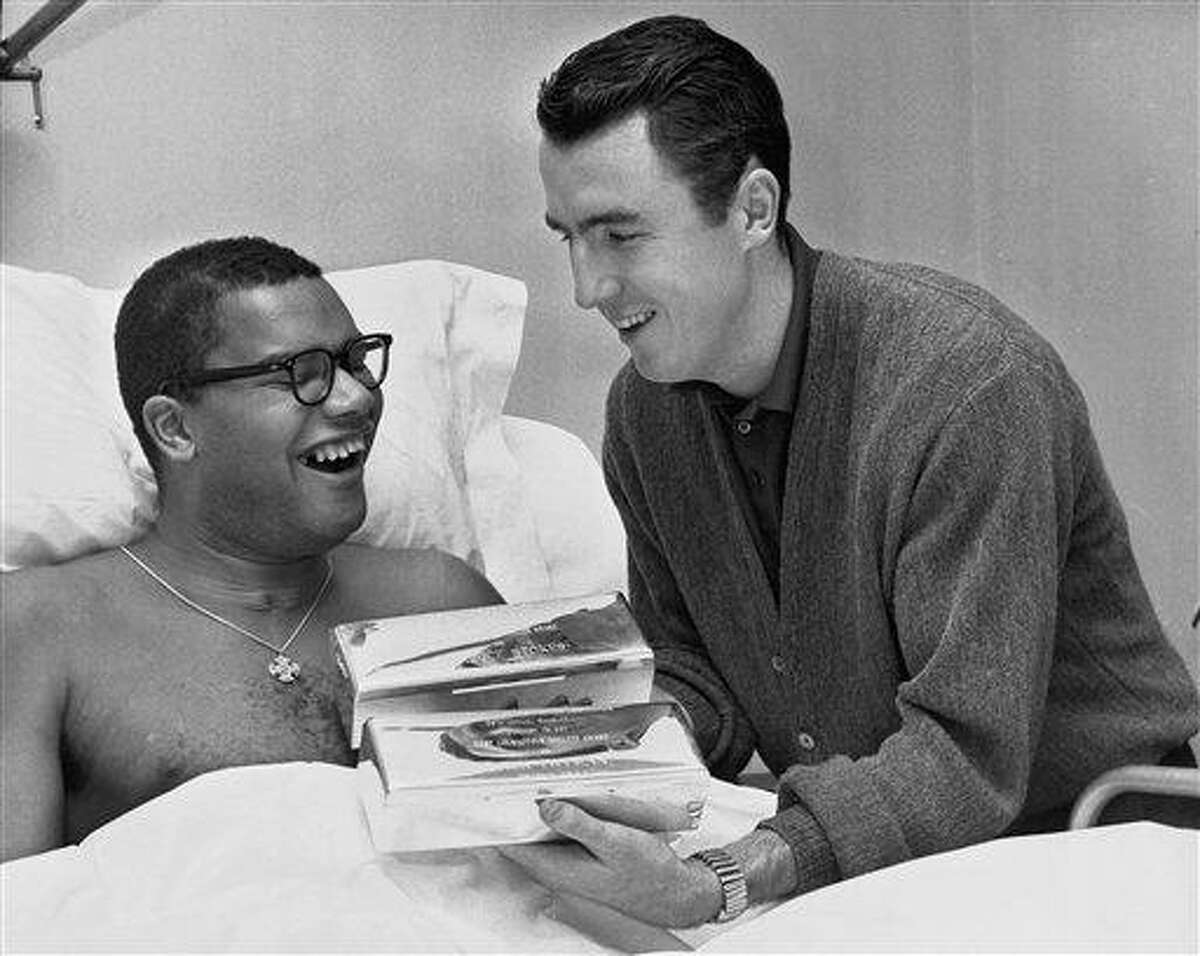 In this 1962 file photo, Jack Twyman, right, holds the trophies he and Maurice Stokes received from the Philadelphia Sports Writers Association designating them as the "Most Courageous Athletes" in Stokes' hospital room in Cincinnati, Ohio. Twyman, a Basketball Hall of Famer, has died at 78. He was one of the NBA's top scorers in the 1950s who became the guardian to paralyzed teammate, Stokes. Associated Press
