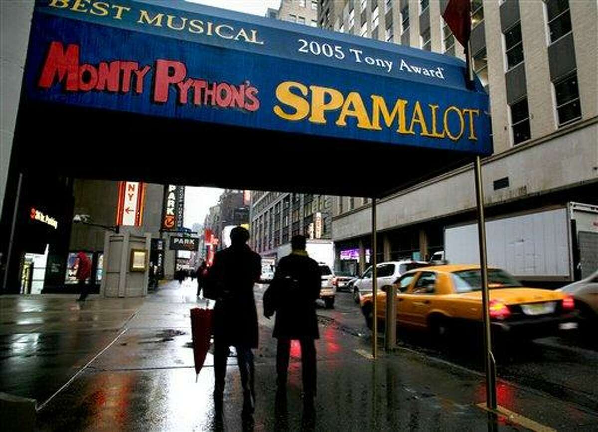 In this 2008 file photo, pedestrians walk under the marquee of the Broadway show "Monty Python's Spamalot" at the Shubert Theatre in New York. A producer of the film "Monty Python and the Holy Grail" is suing the comedy troupe over royalties from the hit stage musical "Spamalot." Producer Mark Forstater wants a bigger share of proceeds from the show, which is based on the 1975 movie spoof of the legend of King Arthur. Python members Eric Idle, Michael Palin and Terry Jones are to give evidence during a five-day hearing that began Friday, at London's High Court. ASSOCIATED PRESS PHOTO/Craig Ruttle, File