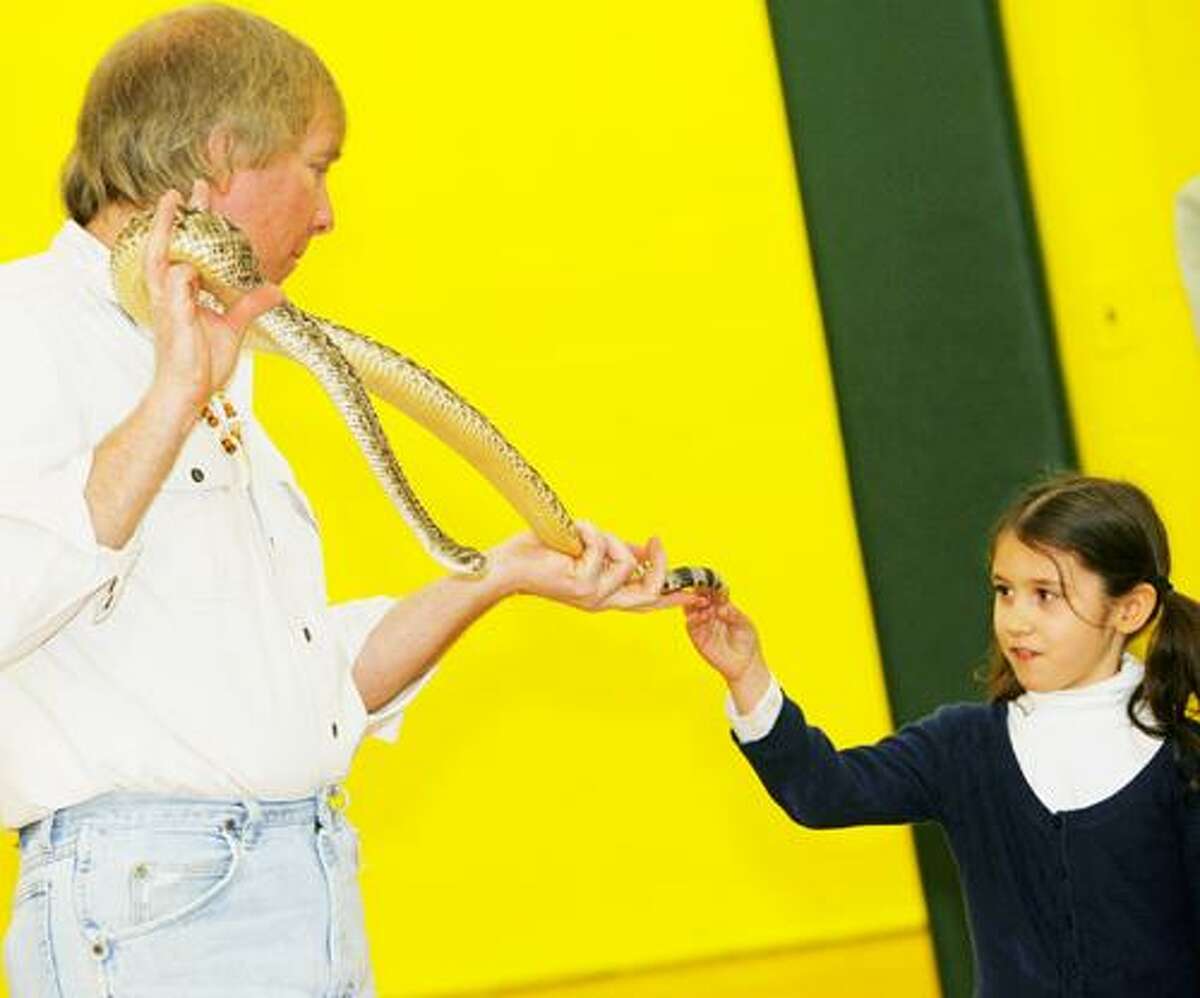 Photo by JOHN HAEGER (Twitter.com/OneidaPhoto) Dan "The Snake Man" Chase holds a diamond back rattle snake as St. Patrick's second grader Isabella Stechyshyn touches its rattle during a program at the school Thursday, Jan. 27 2012 in Oneida.