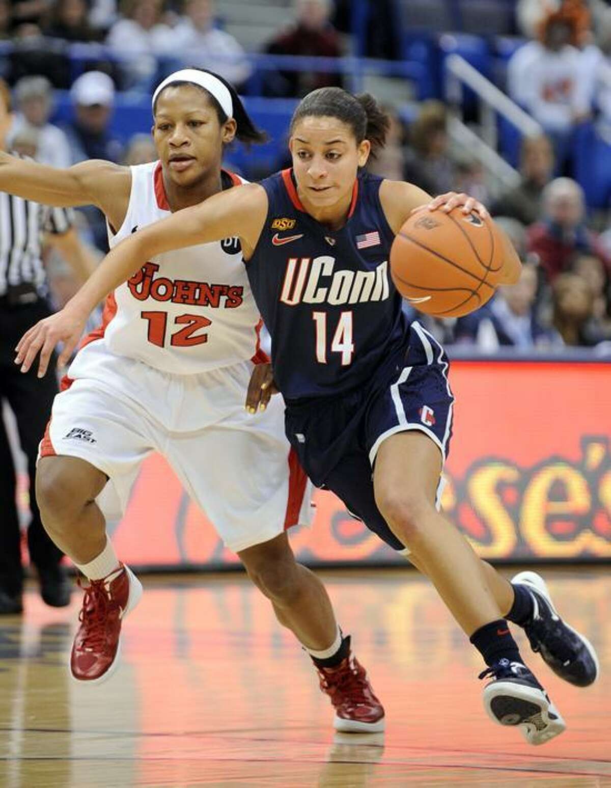 Connecticut's Bria Hartley, right, drives past St. John's Briana Brown during the first half Connecticut's 74-43 victory in an NCAA college basketball game in the semifinals of the Big East women's tournament in Hartford, Conn., Monday, March 5, 2012. (AP Photo/Fred Beckham)