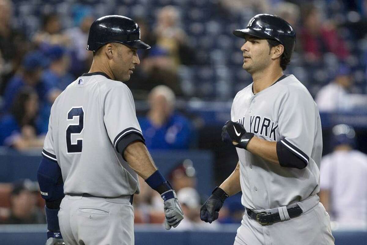 New York Yankees' Eric Chavez, right, is congratulated by Derek Jeter after hitting a home run against the Toronto Blue Jays during the ninth inning of a baseball game in Toronto on Friday, Sept. 28, 2012. (AP Photo/The Canadian Press, Chris Young)