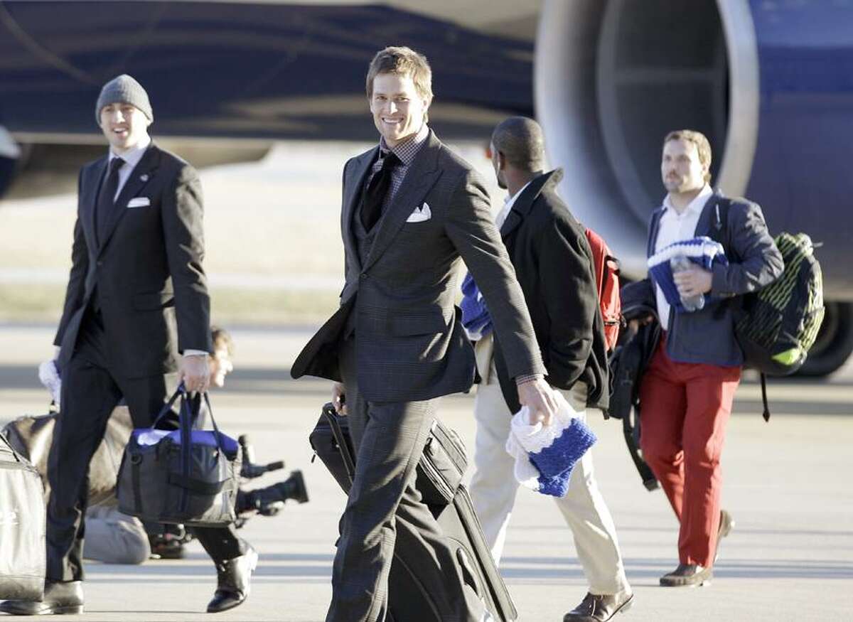 New England Patriots quarterback Tom Brady smiles as the team arrives at the Indianapolis International Airport for NFL footbal's Super Bowl XLVI Sunday, Jan. 29, 2012, in Indianapolis. (AP Photo/David J. Phillip)
