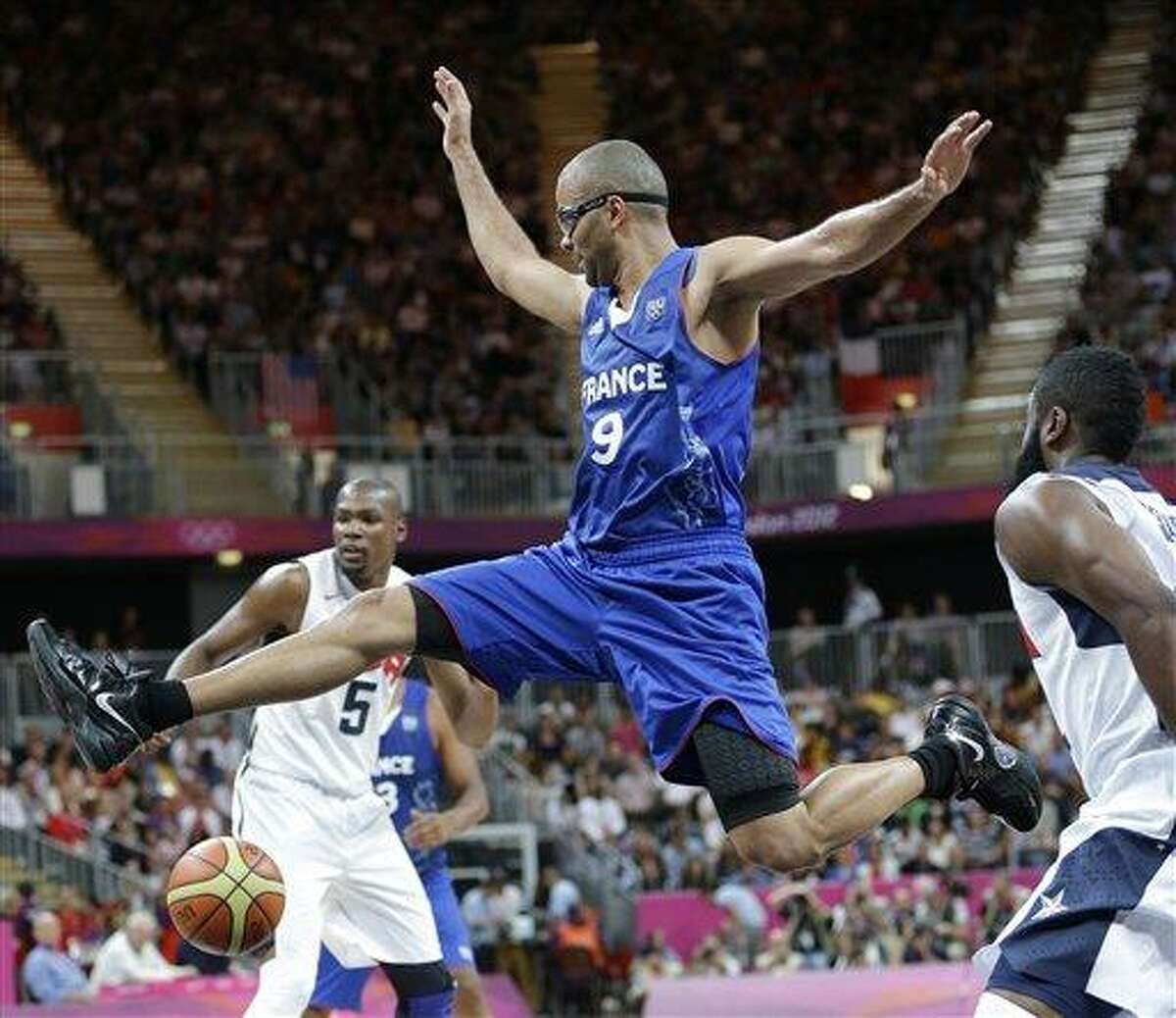 United States' James Harden, right, strips the ball from France's Tony Parker (9) during the first half of a preliminary men's basketball game at the 2012 Summer Olympics Sunday in London. Associated Press