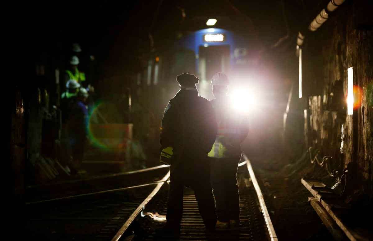 John Burkhard, right, assistant superintendent for the Way and Structures Division of the Port Authority Trans-Hudson train line, stands next to a police officer as a PATH train passes in the tunnel, Tuesday, Nov. 27, 2012, in Hoboken, N.J. While parts of the trans-Hudson service have gradually returned to operation since Superstorm Sandy, the Hoboken station has been closed, leaving thousands of commuters to seek alternatives. (AP Photo/Julio Cortez)