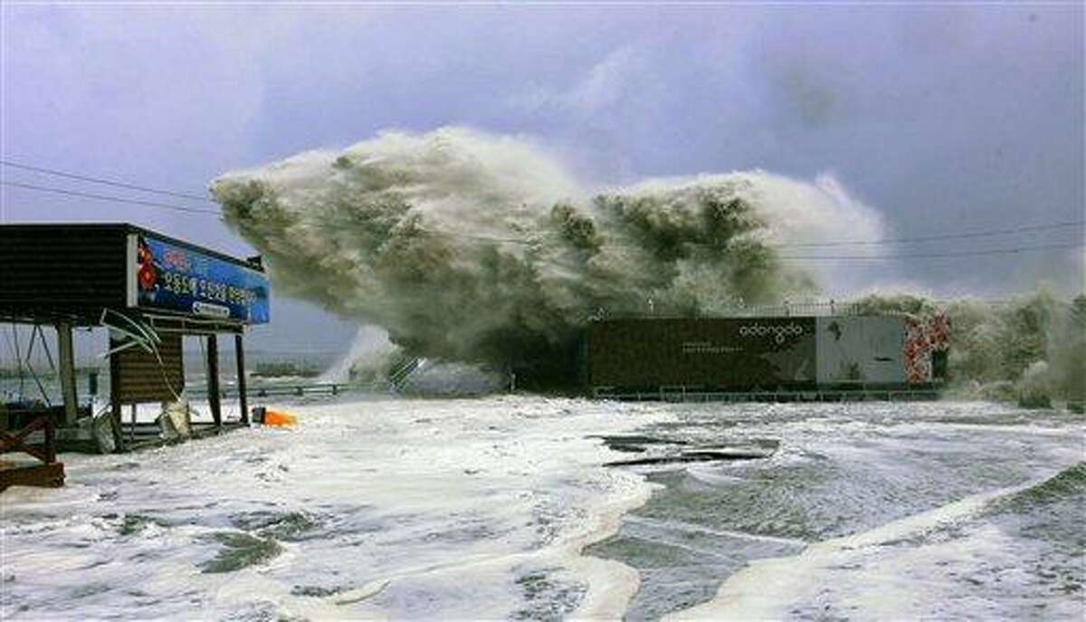 In this photo released by Yeosu City and distributed via Yonhap News Agency, high waves caused by Typhoon Sanba crash on a beach Monday in Yeosu, south of Seoul, South Korea. Associated Press