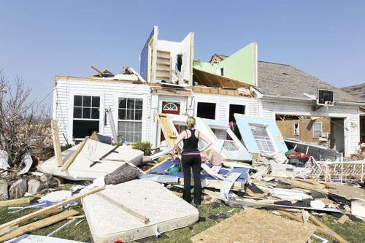AP Photo Katie Cramer looks over the front of her house in Dexter, Mich., Friday, after a tornado touched down on Thursday night, damaging or demolishing many homes, downing trees and power lines. No one died or was seriously injured in the tornado's 10-mile path of destruction.