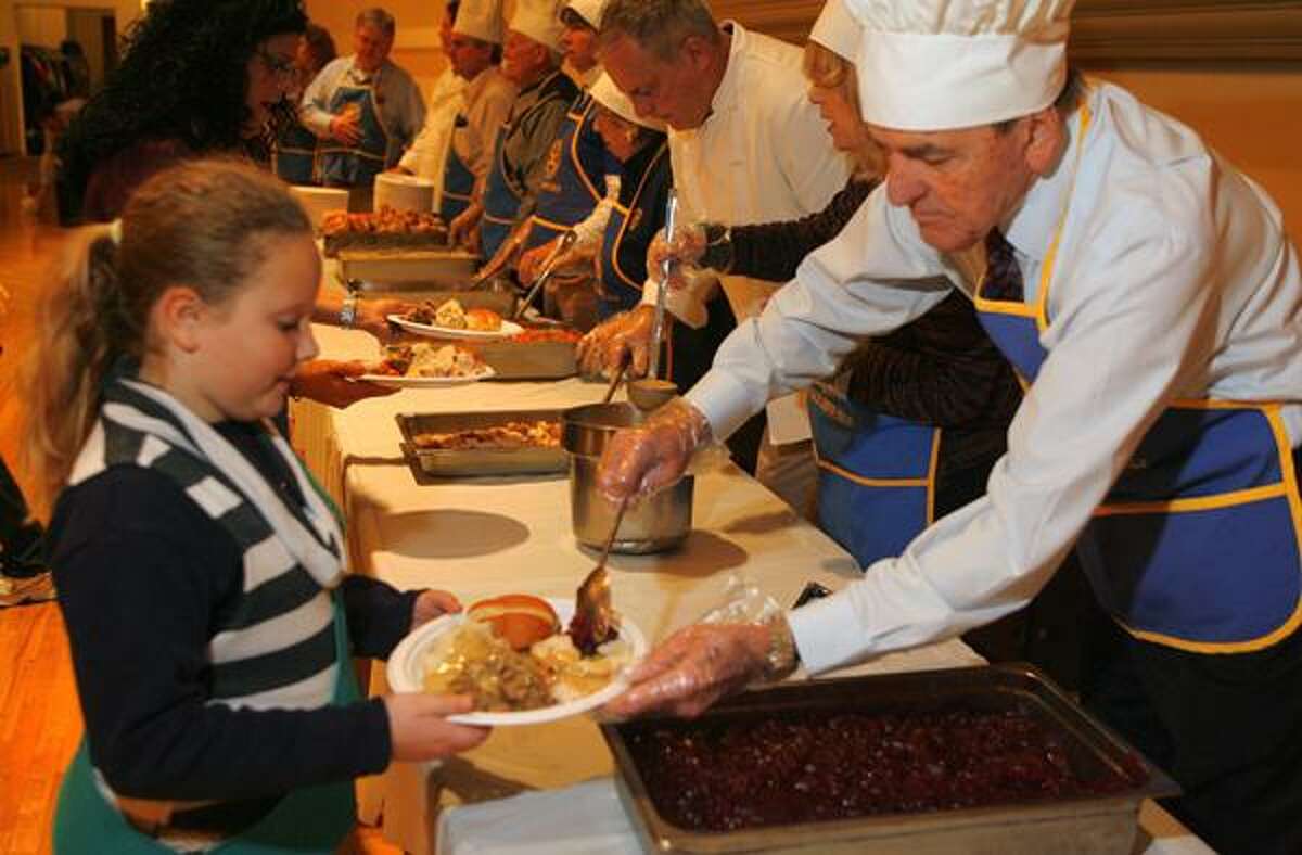 Dispatch Staff Photo by JOHN HAEGER twitter.com/oneidaphoto Girl Scout Troop 243 member Haylee Emmons, then-10, holds a plate as Jerry Gortner places cranberry sauce on the plate to be served during the annual Rotary Thanksgiving Dinner on Wed. Nov. 23, 2011 at the Kallet Civic Center in Oneida.