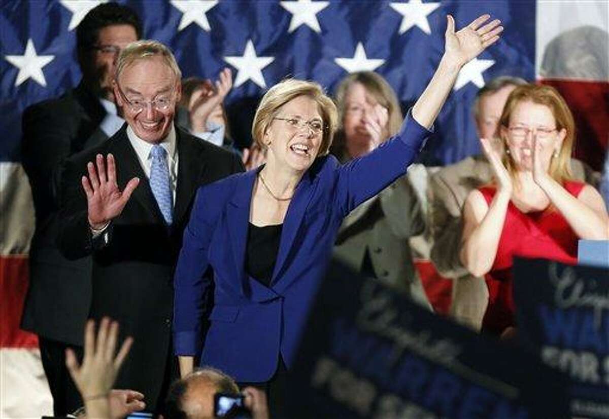 Democrat Elizabeth Warren, center, waves to the crowd with her husband Bruce Mann, left, during an election night rally at the Fairmont Copley Plaza hotel in Boston after Warren defeated incumbent GOP Sen. Scott Brown in the Massachusetts Senate race. (AP Photo)