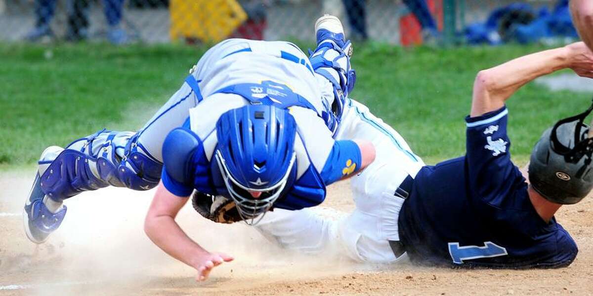 Seymour catcher Mike Conlan (left) flies into the air after tagging Mike Palmquist (right) of Ansonia out at the plate on Monday. Ansonia won 7-5. Photo by Arnold Gold/New Haven Register