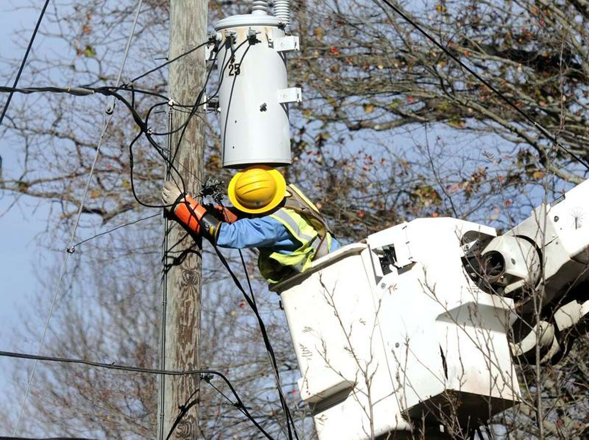 Green Mountain Power (Vermont) lineman Adam Eisel works to get three houses on Featherbed Lane in Branford back up and running on power. Mara Lavitt/New Haven Register11/3/12