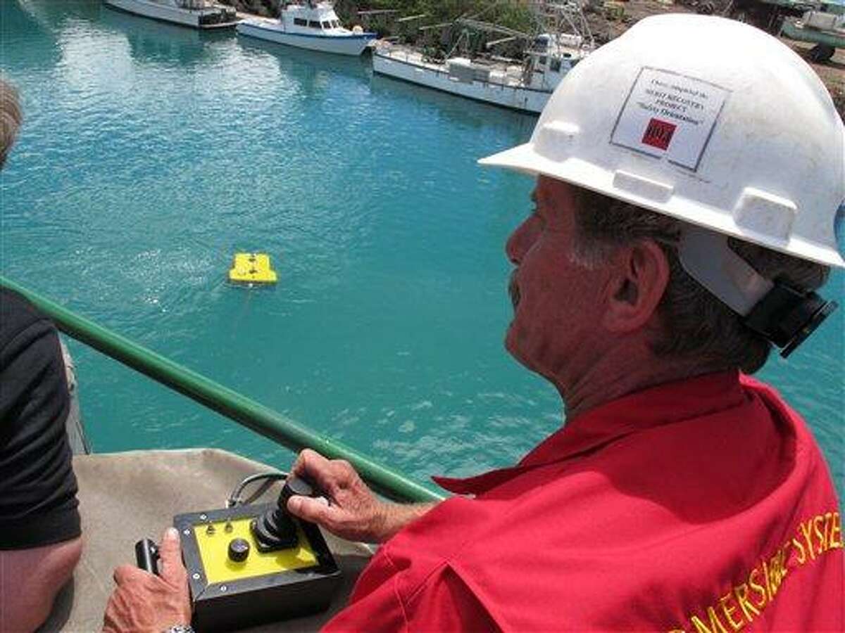 Wolfgang Burnside controls a remote-operated vehicle from the deck of a ship in Honolulu on Sunday, July 1, 2012. Cameras and lights on the vehicle will be used to search the ocean floor during a month-long voyage to find plane wreckage from Amelia Earhart's Lockheed Electra, which disappeared over the South Pacific 75 years ago. (AP Photo/Oskar Garcia)