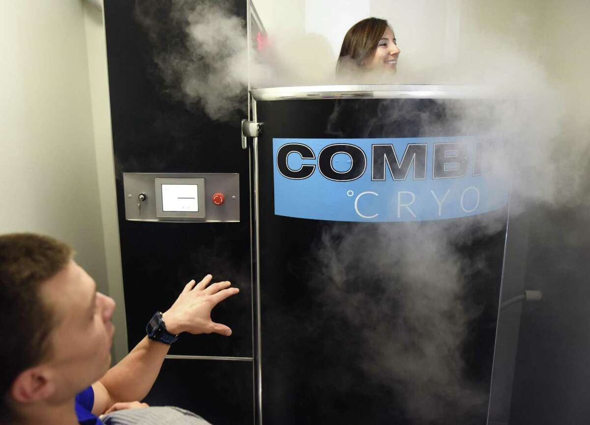 Cryotherapy supervisor Max Tremain assists operations manager Christina Vitale in the Cryosauna at Combine Training in Greenwich, Conn. Tuesday, July 18, 2017. Cryotherapy exposes the body to extremely low temperatures for a short period of time and is said to prompt quick recovery after a workout and release endorphins to give a feeling similar to a "runner's high."
