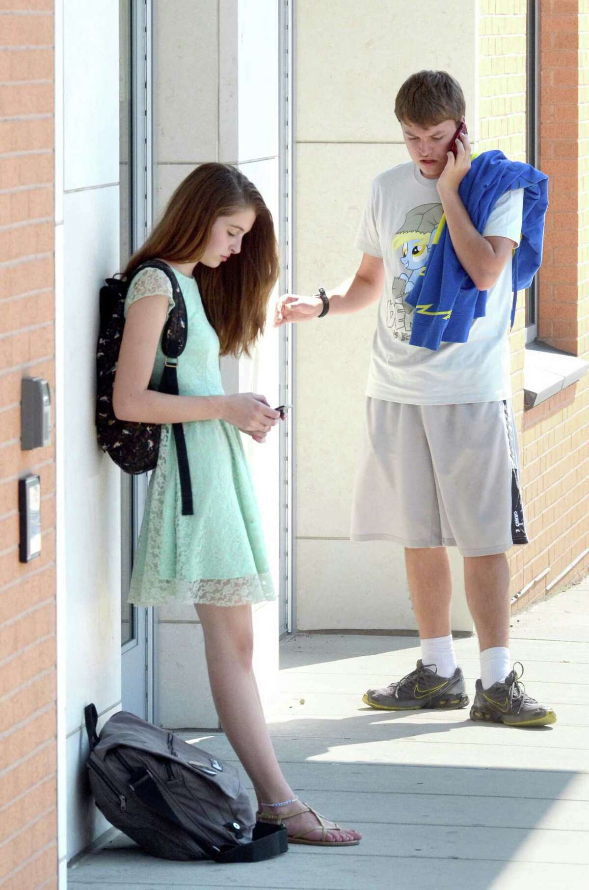 Coop High School Tenth graders Ilana Zsigmond and Tyler Ambrose, both of Hamden use their phones after school August 31, 2012 on College Ave in New Haven. vmWilliams