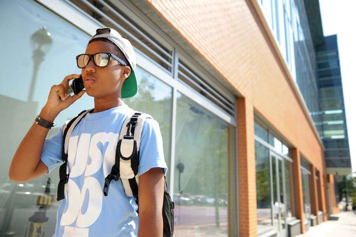 Cameron Twitty, a senior from New Haven, talks on his cell phone outside of Coop High School on College Ave Friday afternoon August 31, 2012