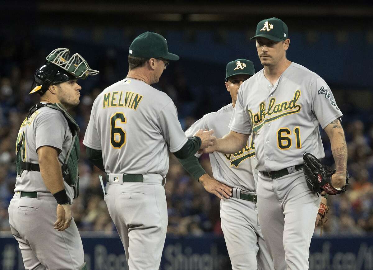Oakland Athletics manager Bob Melvin takes pitcher John Axford (61) out of the game after he loads the bases in the seventh inning of a baseball game against the Toronto Blue Jays in Toronto, Monday, July 24, 2017. (Fred Thornhill/The Canadian Press via AP)