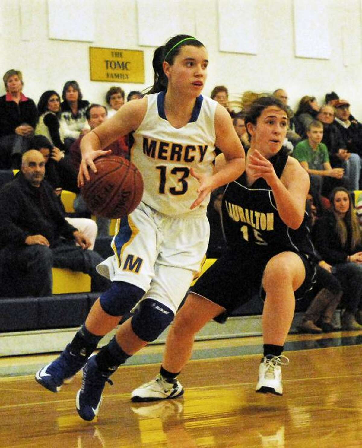 Catherine Avalone/The Middletown Press Mercy senior captain Maria Weselyj drives as Lauralton Hall junior Maureen Connolly defends during the Mercy Classic championship game Friday night. The Mercy Tiges defeated the Lauralton Hall Crusaders 66-47.