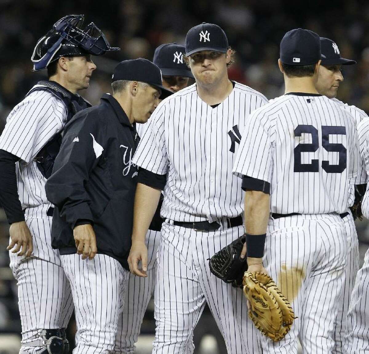 ASSOCIATED PRESS New York Yankees starting pitcher Phil Hughes, center, reacts as he leaves the mound in the sixth inning after manager Joe Girardi, second from left, took Hughes out during the Yankees' 7-1 loss to the Baltimore Orioles on Tuesday night at Yankee Stadium in New York. Yankees catcher Chris Stewart, left, third baseman Alex Rodriguez, first baseman Mark Teixeira (25) and shortstop Derek Jeter joined Hughes on the mound.
