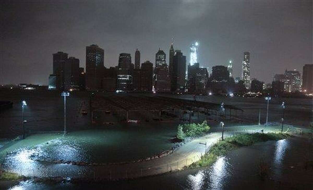 Lower Manhattan goes dark during hurricane Sandy, on Monday, Oct. 29, 2012, as seen from Brooklyn, N.Y. Sandy continued on its path Monday, as the storm forced the shutdown of mass transit, schools and financial markets, sending coastal residents fleeing, and threatening a dangerous mix of high winds and soaking rain. (AP Photo/Bebeto Matthews)