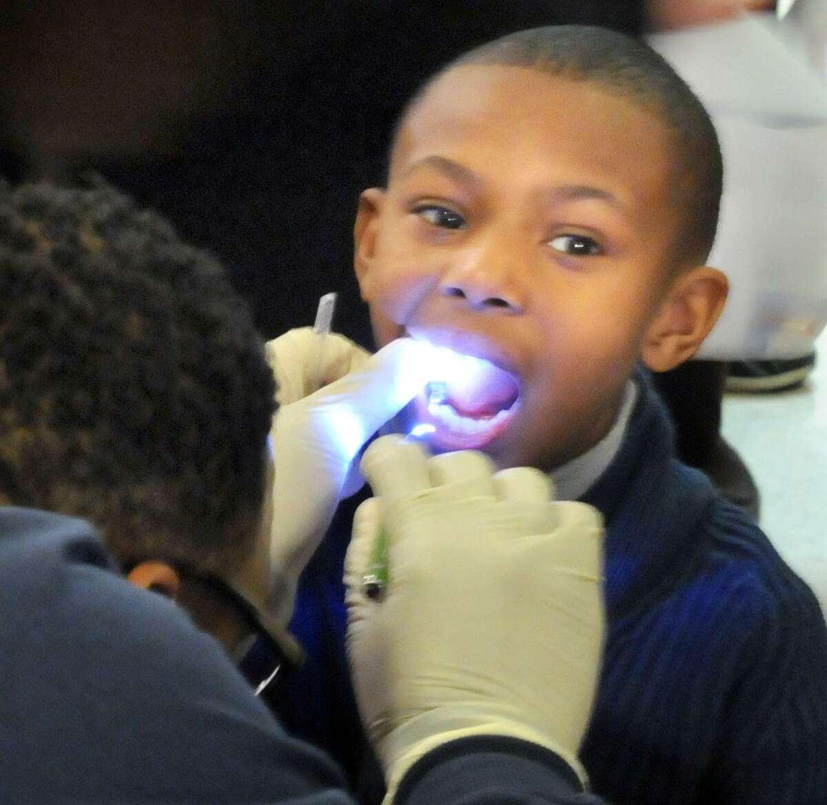 Xerox underwrote a visit by area dental professionals to Savin Rock Community School in West Haven to give a free dental exam to pre-K through 2nd grade students. Lajajuan Dancy Jr. age 8 getting his exam from pediatric dentist Dr. Darnell Young of Elm Family Dental, West Haven. Photo by Mara Lavitt/New Haven Register2/28/12