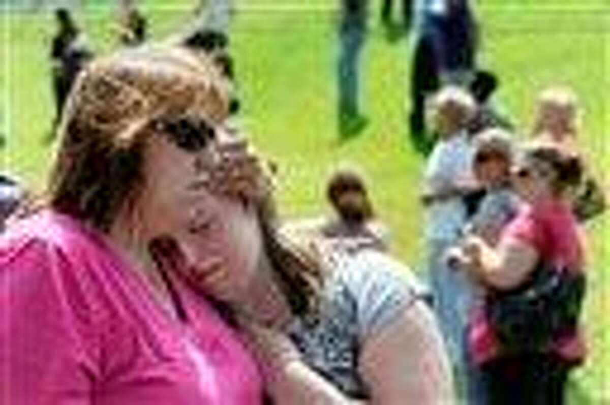 Tracie Bradford, of Perry Hall, Md., consoles her daughter Leah, a student at Perry Hall High School who says she was in the school's cafeteria when a student was shot there and critically wounded on the first day of classes. Associated Press photo