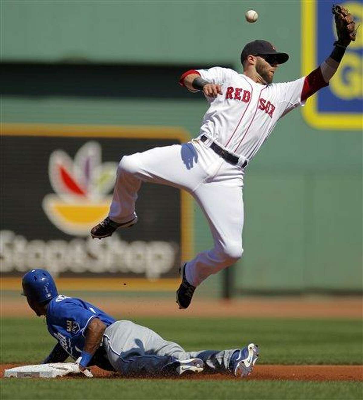 Kansas City Royals' Jarrod Dyson, bottom, steals second base as Boston Red Sox's Dustin Pedroia tries to get his glove on the ball in the first inning of a baseball game at Fenway Park, Monday, Aug. 27, 2012. (AP Photo/Steven Senne)