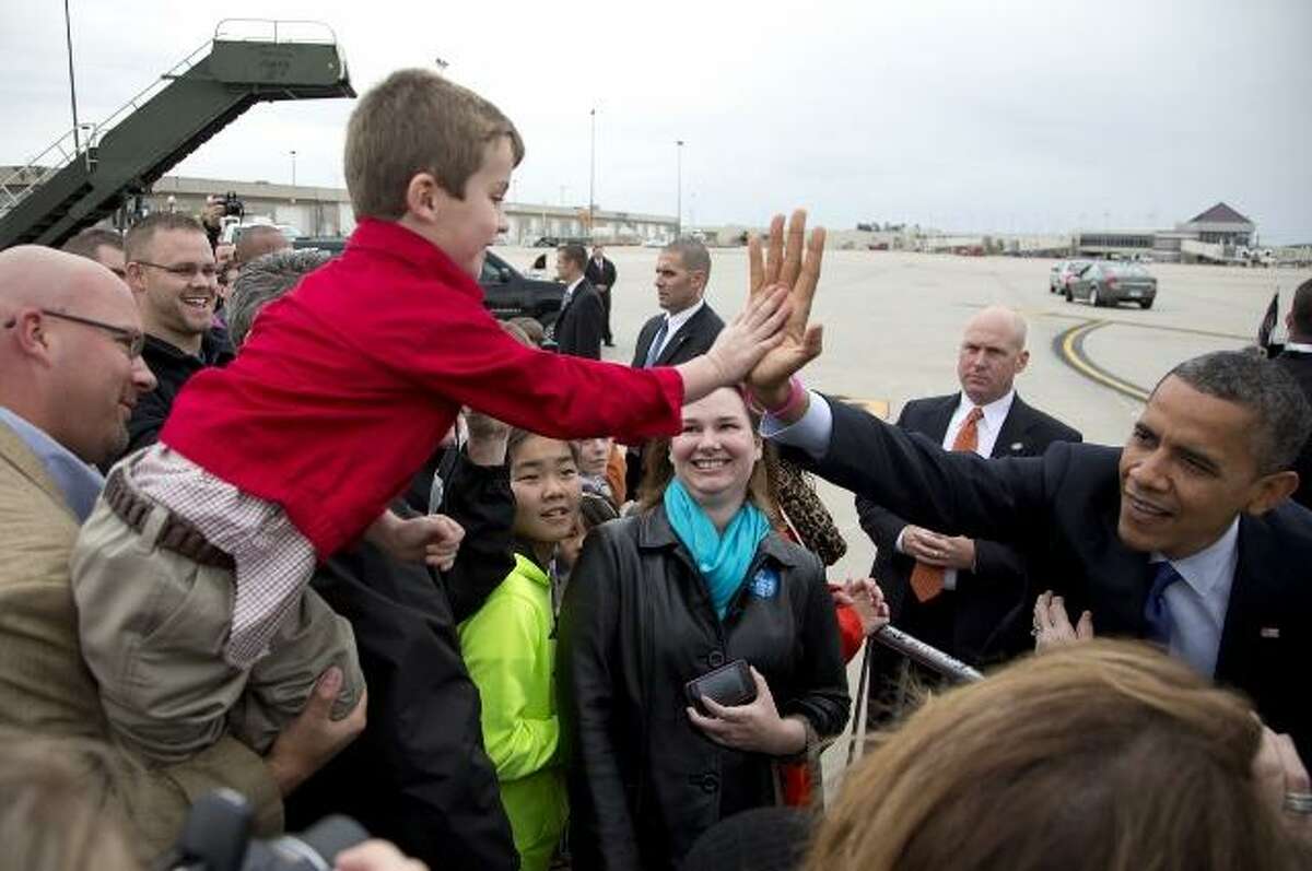 President Obama high-fives a boy at a campaign stop in Ohio Oct. 17. (AP photo)