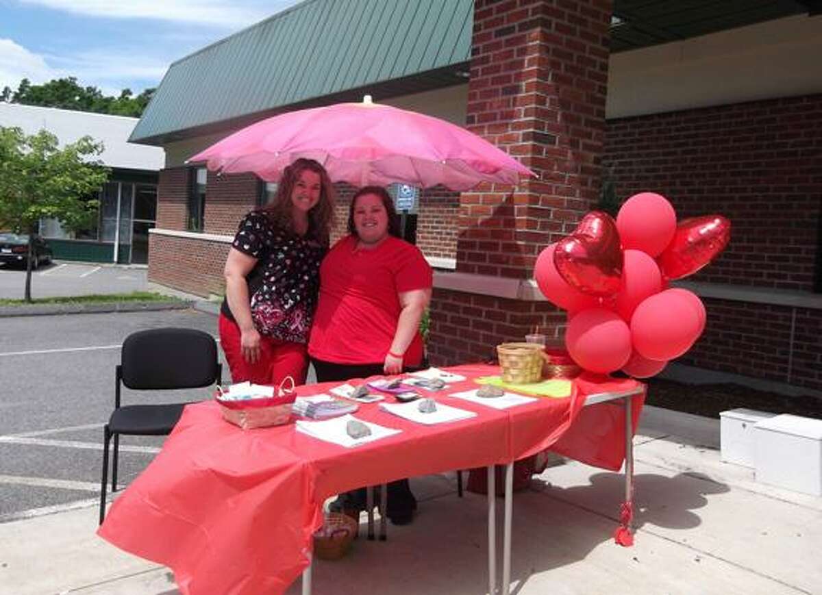 MICHELLE MERLIN/Register Citizen Stephanie Markey and Jessica VanDine, nurses who work for the Ryan White Foundation to help HIV/AIDS patients, promote testing outside the Community Health & Wellness Center of Greater Torrington and pass out condoms and informational pamphlets.