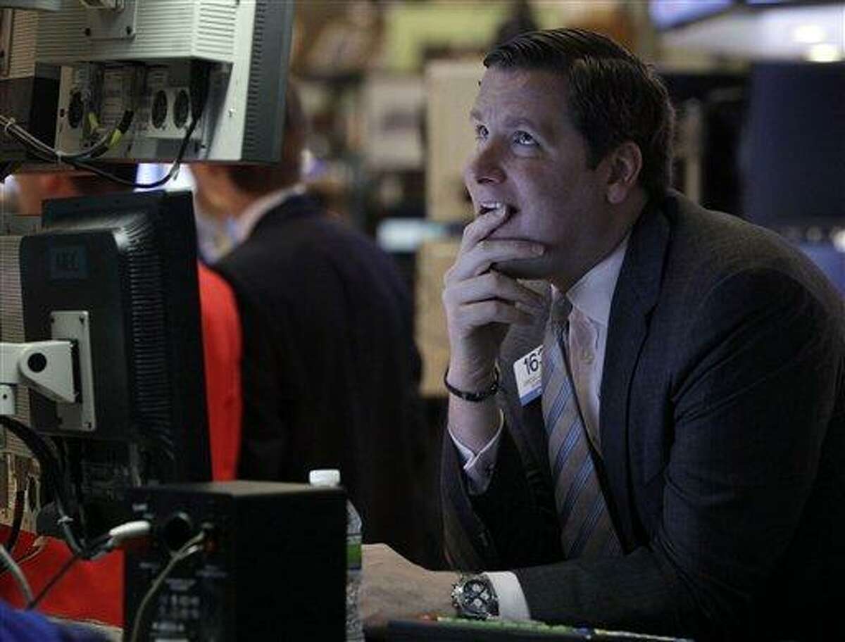 In this file photo, Specialist Gregg Maloney works on the floor of the New York Stock Exchange. Stock futures slid Thursday until the U.S. Supreme Court's ruling on the federal health care law, and then hospital stocks rose sharply. Associated Press