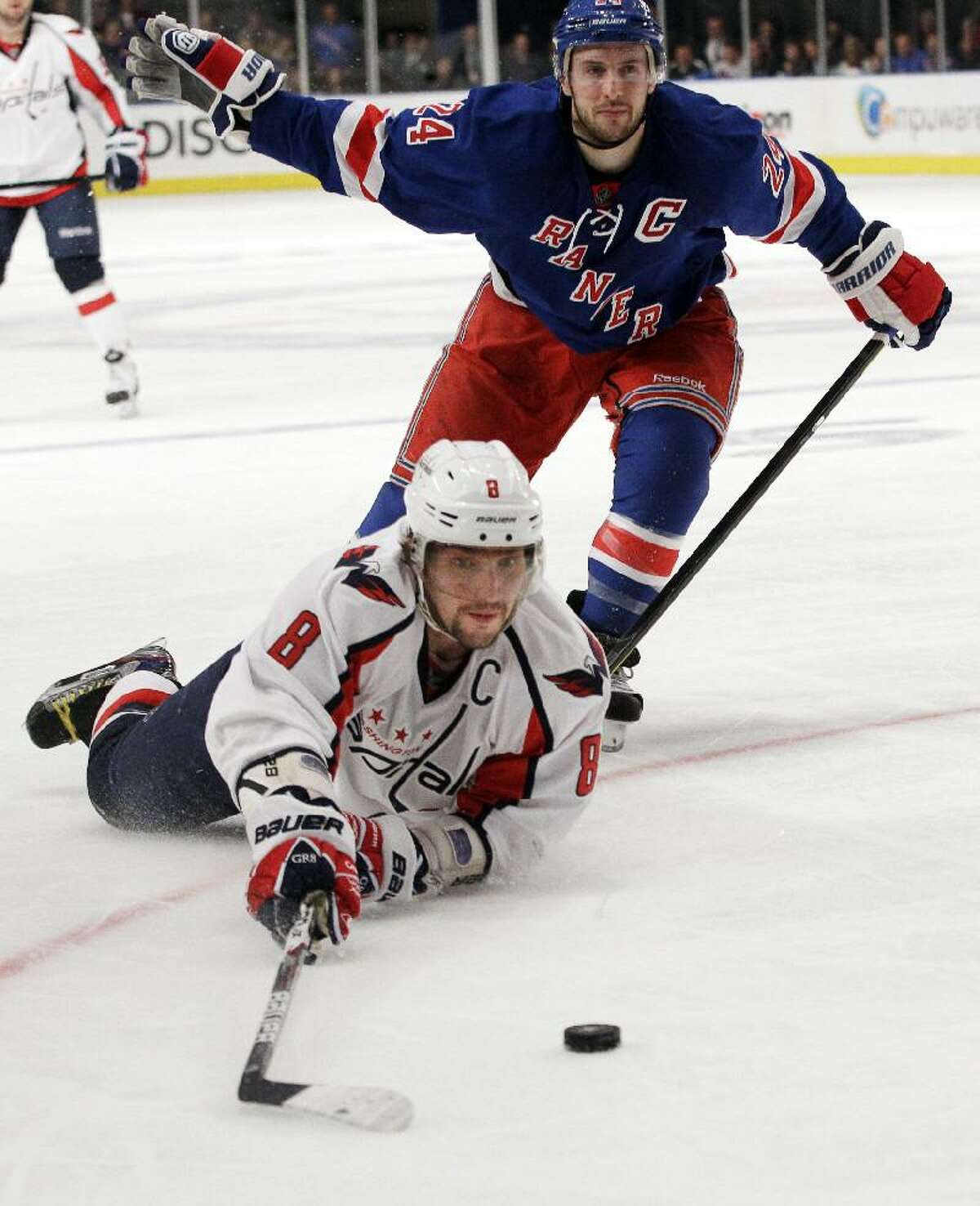 ASSOCIATED PRESS Washington Capitals' Alex Ovechkin (8) falls to the ice while fighting for control of the puck with New York Rangers' Ryan Callahan (24) during the third period of Game 1 of an NHL Stanley Cup playoff series Saturday in New York. The Rangers won the game 3-1.