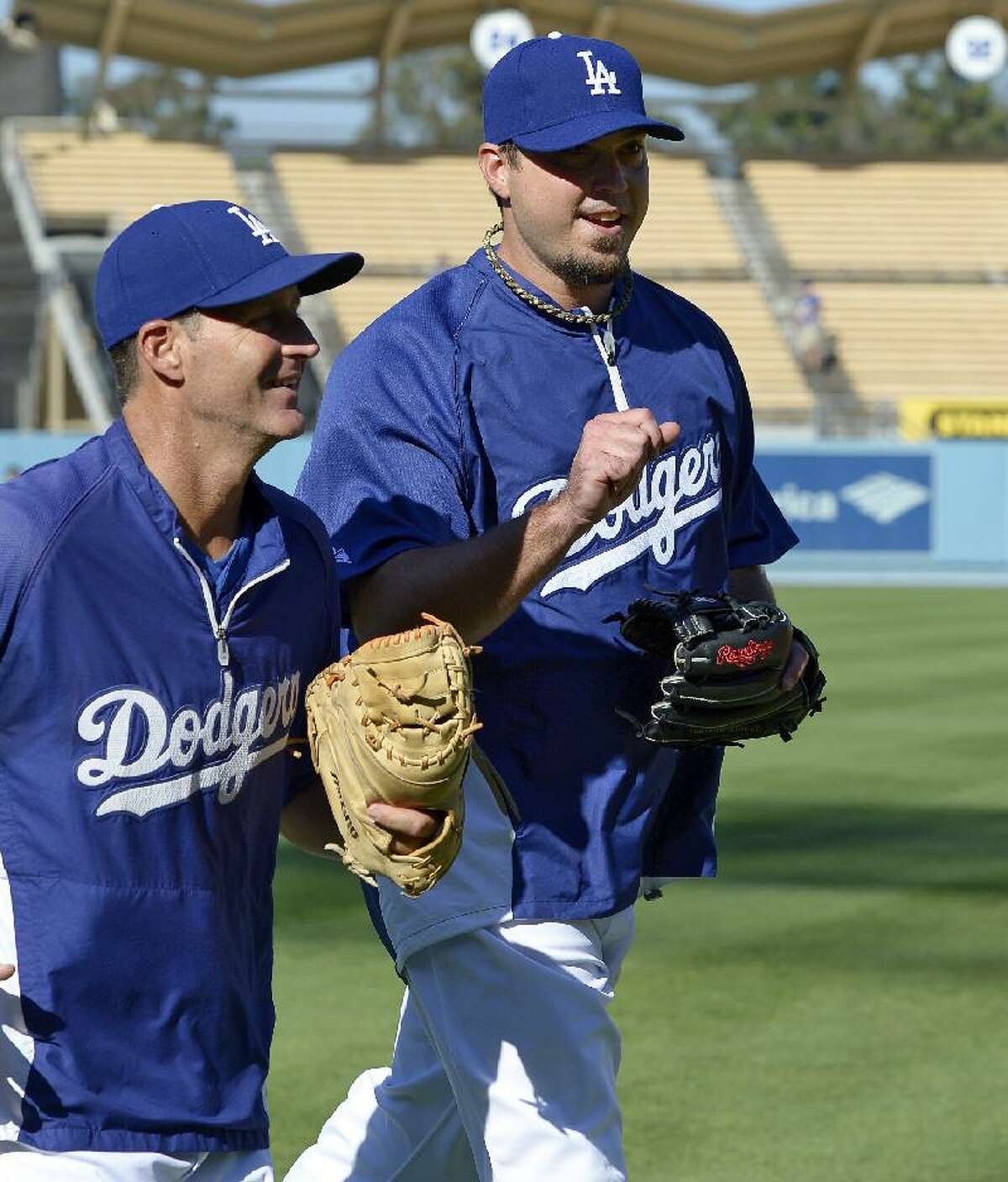 ASSOCIATED PRESS Newly acquired Los Angeles Dodgers pitcher Josh Beckett, right, gestures as he runs off the field with pitching coach Rick Honeycutt prior to the Dodgers' game against the Miami Marlins on Saturday night at Dodger Stadium in Los Angeles.