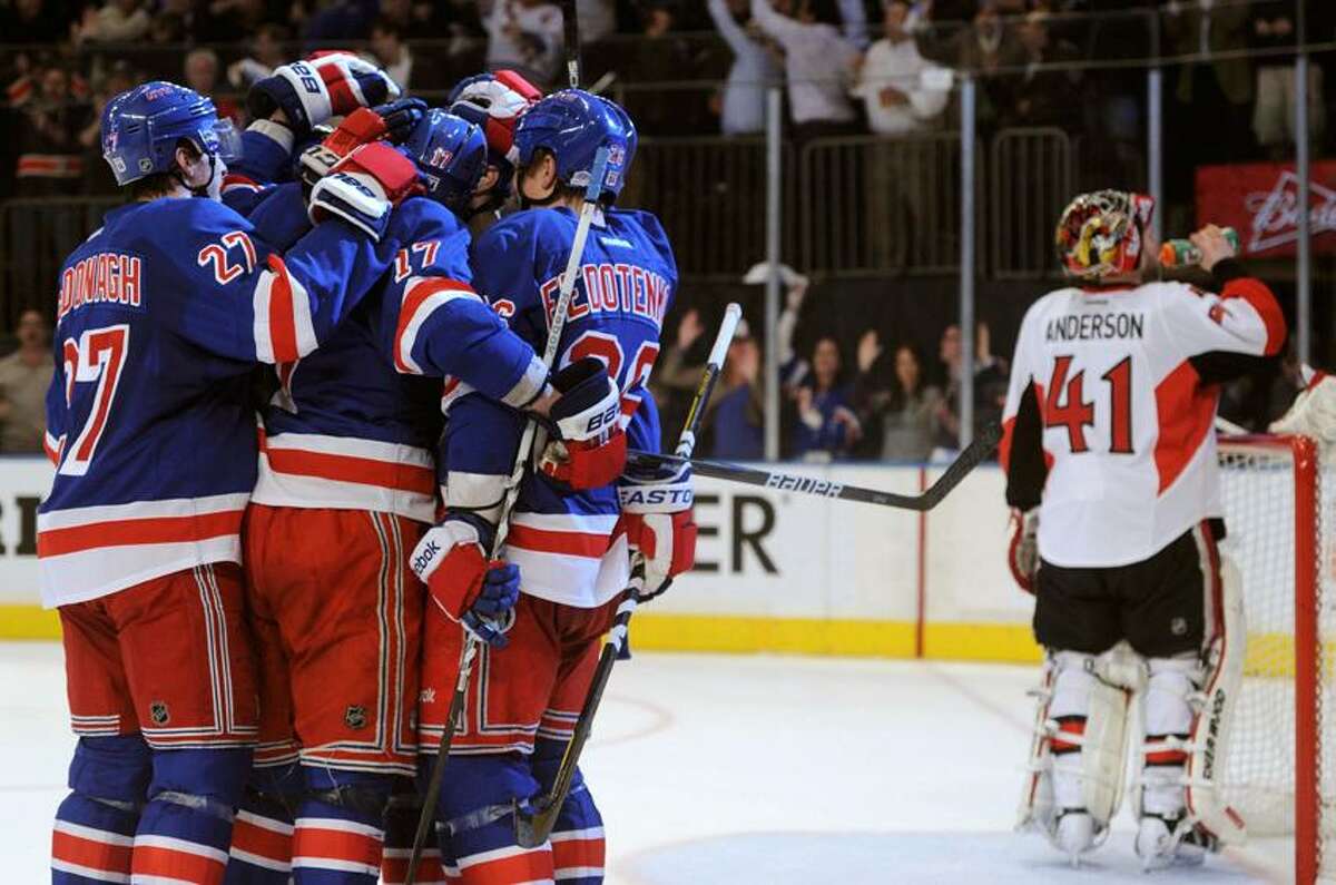 New York Rangers' Dan Girardi is congratulated by his teammates after scoring on Ottawa Senators goalie Craig Anderson (R) during the sceond period in Game 7 of their NHL Eastern Conference quarter-final playoff hockey game in New York, April 26, 2012. REUTERS/Ray Stubblebine (UNITED STATES - Tags: SPORT ICE HOCKEY)