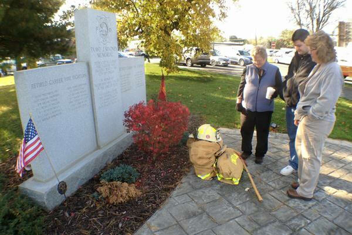 Dispatch Staff Photo by JOHN HAEGER twitter.com/oneidaphoto Pam Hudson (wife) David Hudson (son) and Lynda Hudson (sister) look at the Firemen's Memorial and Don Hudson turnout gear at the base following a memorial at the Oneida Fire Department on Monday Oct. 22, 2012 in Oneida.